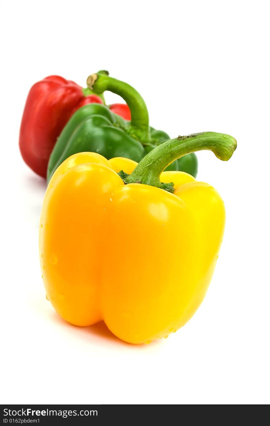 Red, green and yellow bell peppers isolated on white.