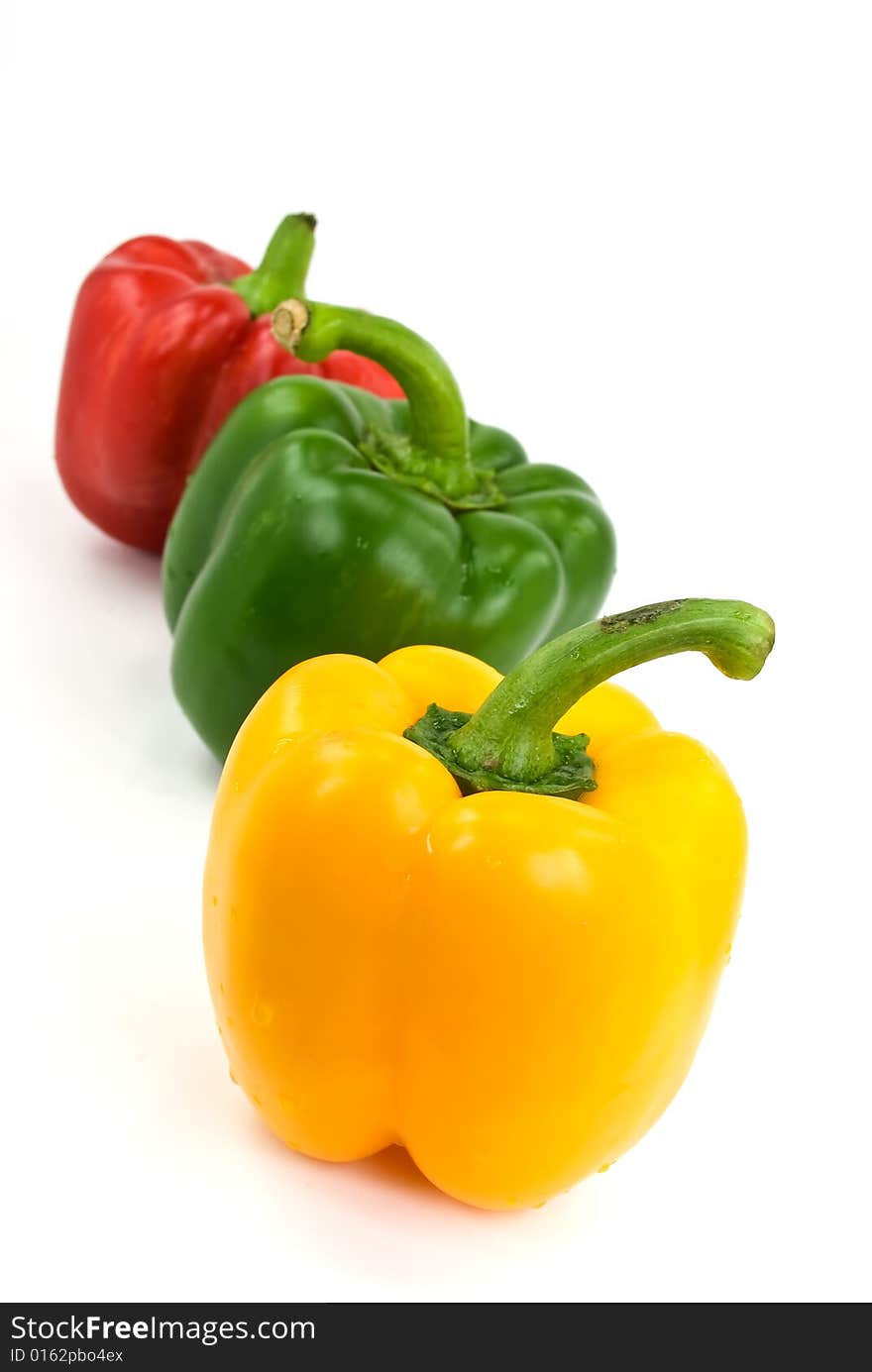 Red, green and yellow bell peppers isolated on white.