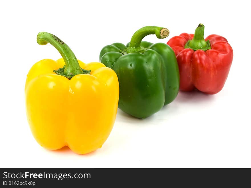 Red, green and yellow bell peppers isolated on white.