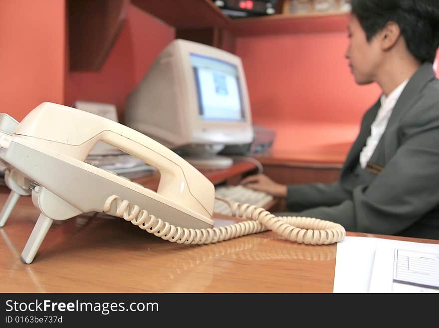 Photograph of secretary at office focused on telephone