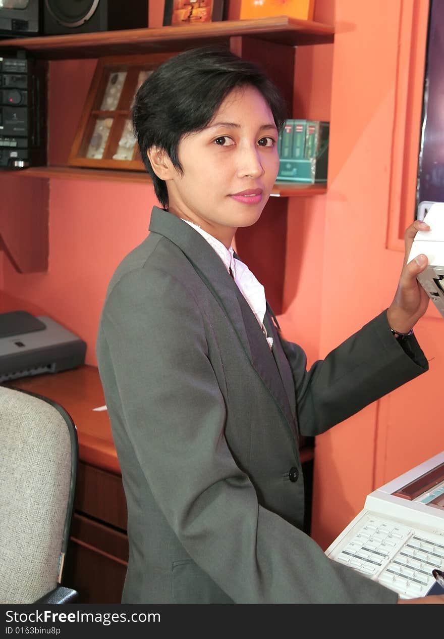 Photograph of secretary at office holding photo copy machine