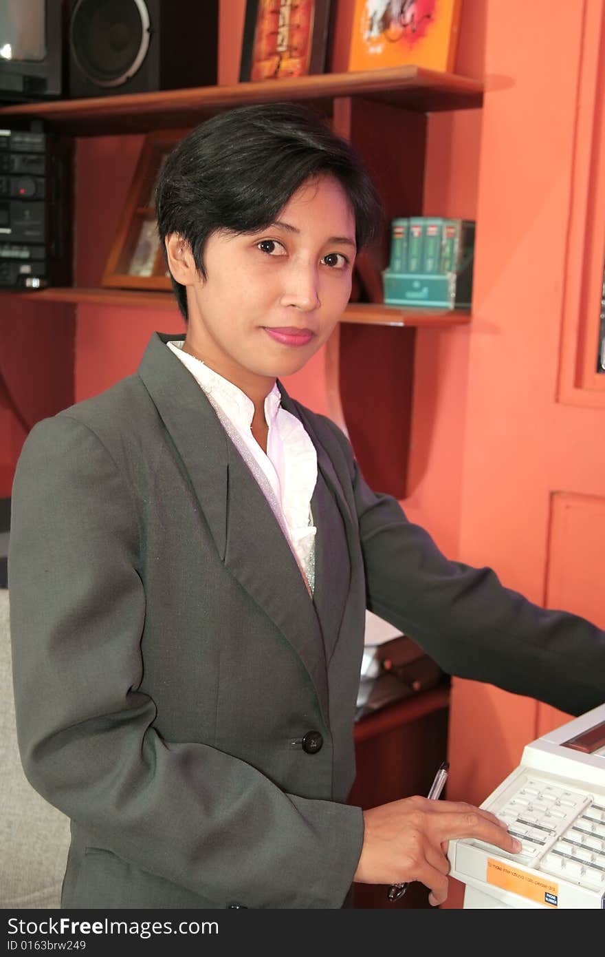 Photograph of secretary at office holding photo copy machine