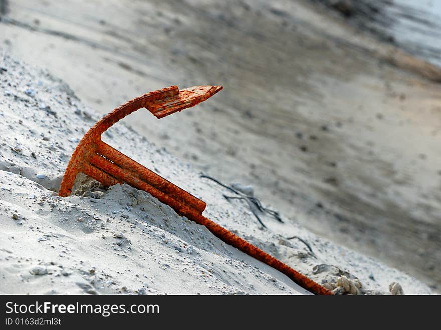 An rusty anchor isolated on beach. An rusty anchor isolated on beach