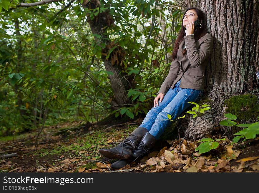 Young woman talking by phone on deep forest. Young woman talking by phone on deep forest