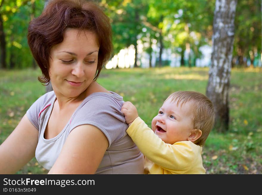 Smiling baby with mother in wood