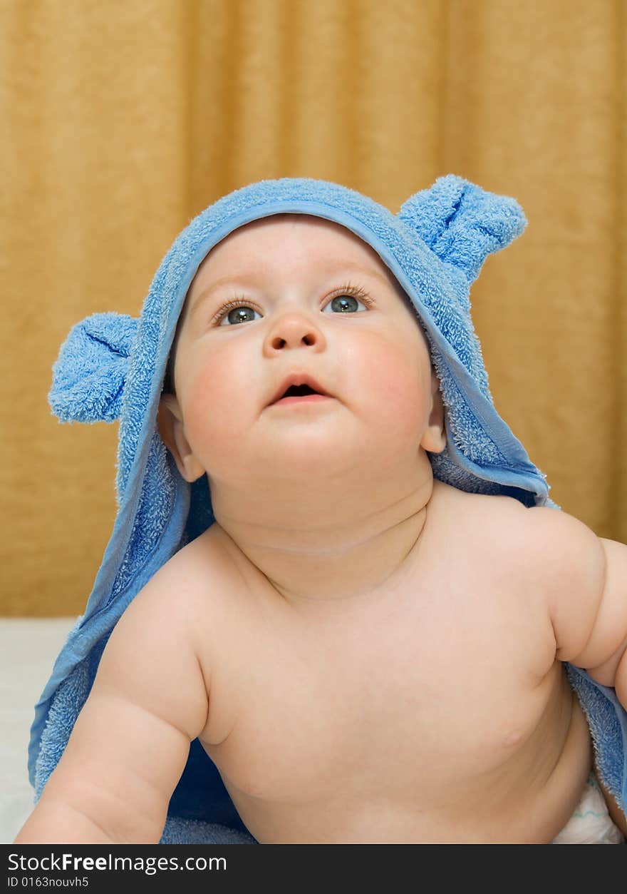 Small smiling baby in blue towel on bed #11. Small smiling baby in blue towel on bed #11