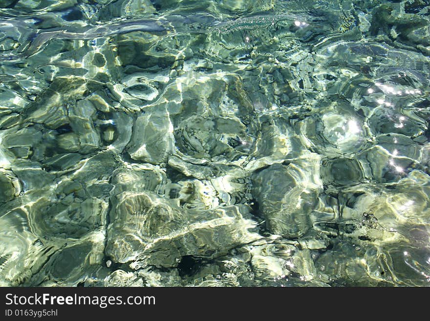 Sea water reflection and pebbles