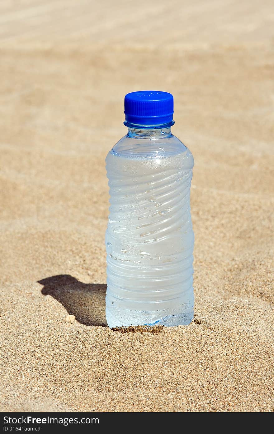 Plastic bottle with water on sand