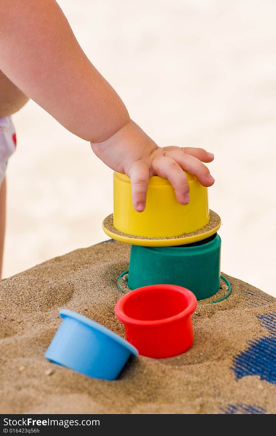 Children's hand and toys on sand. Children's hand and toys on sand