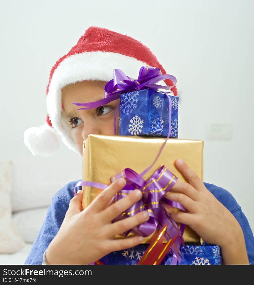 Young boy with Christmas hat and presents. Young boy with Christmas hat and presents