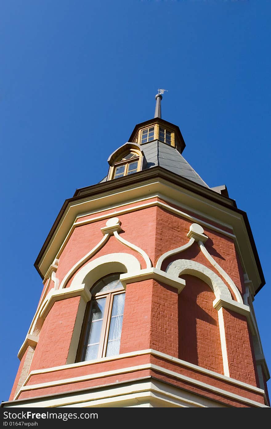 Old red tower on blue ground