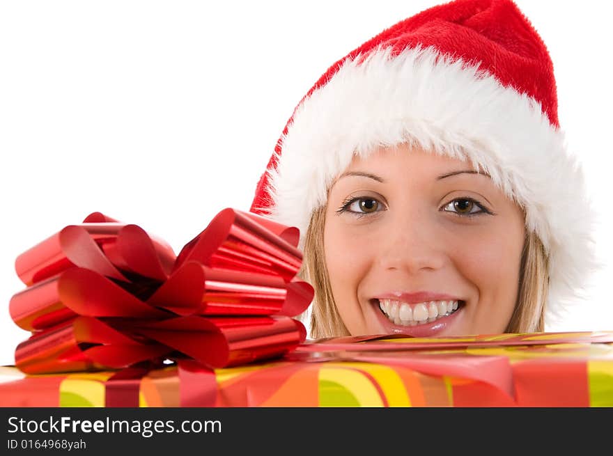 Blond smiling girl with Santa's hat look at the camera between the gift. Isolated image on white background. Blond smiling girl with Santa's hat look at the camera between the gift. Isolated image on white background