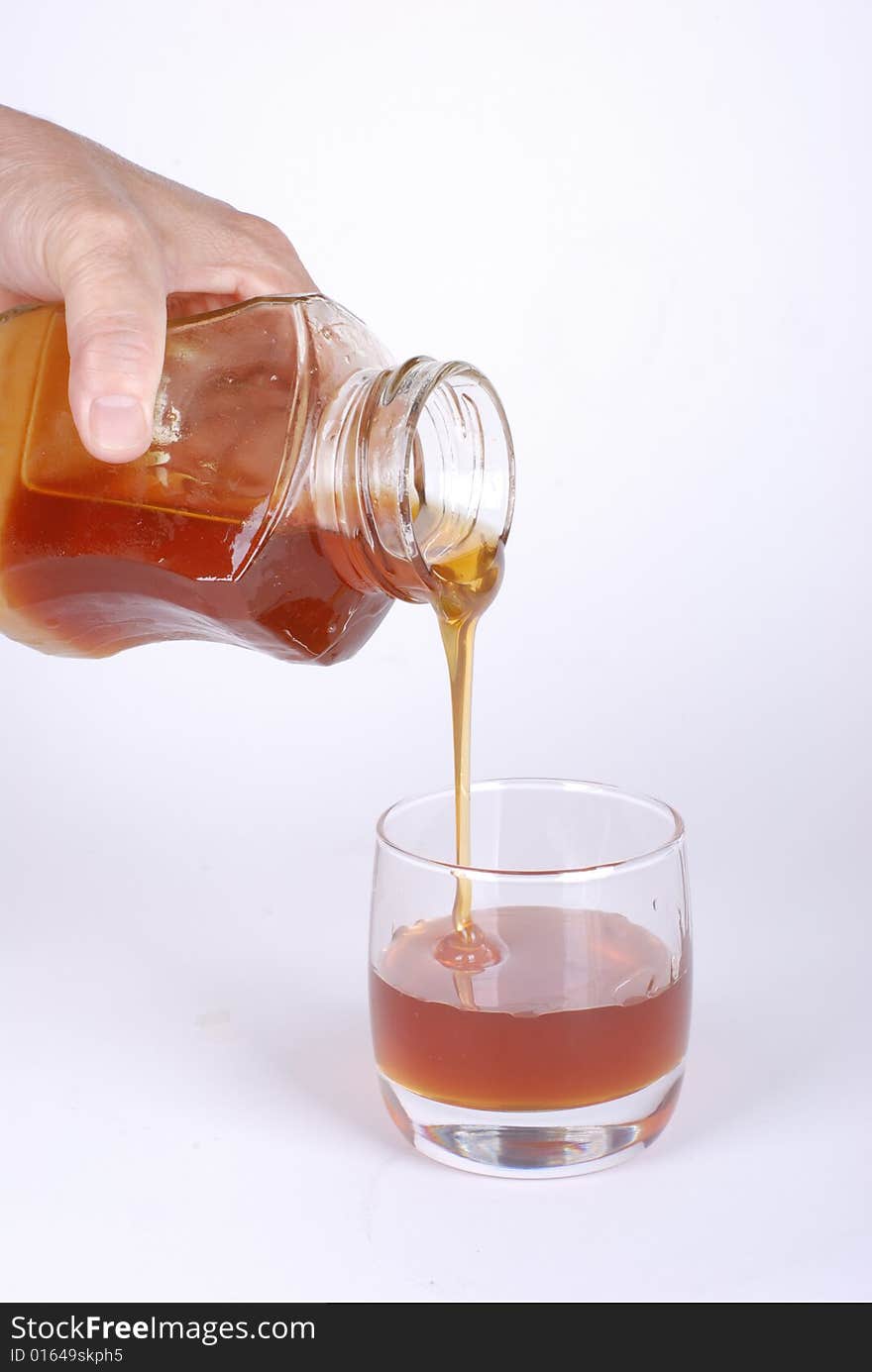 Pouring honey  on white background