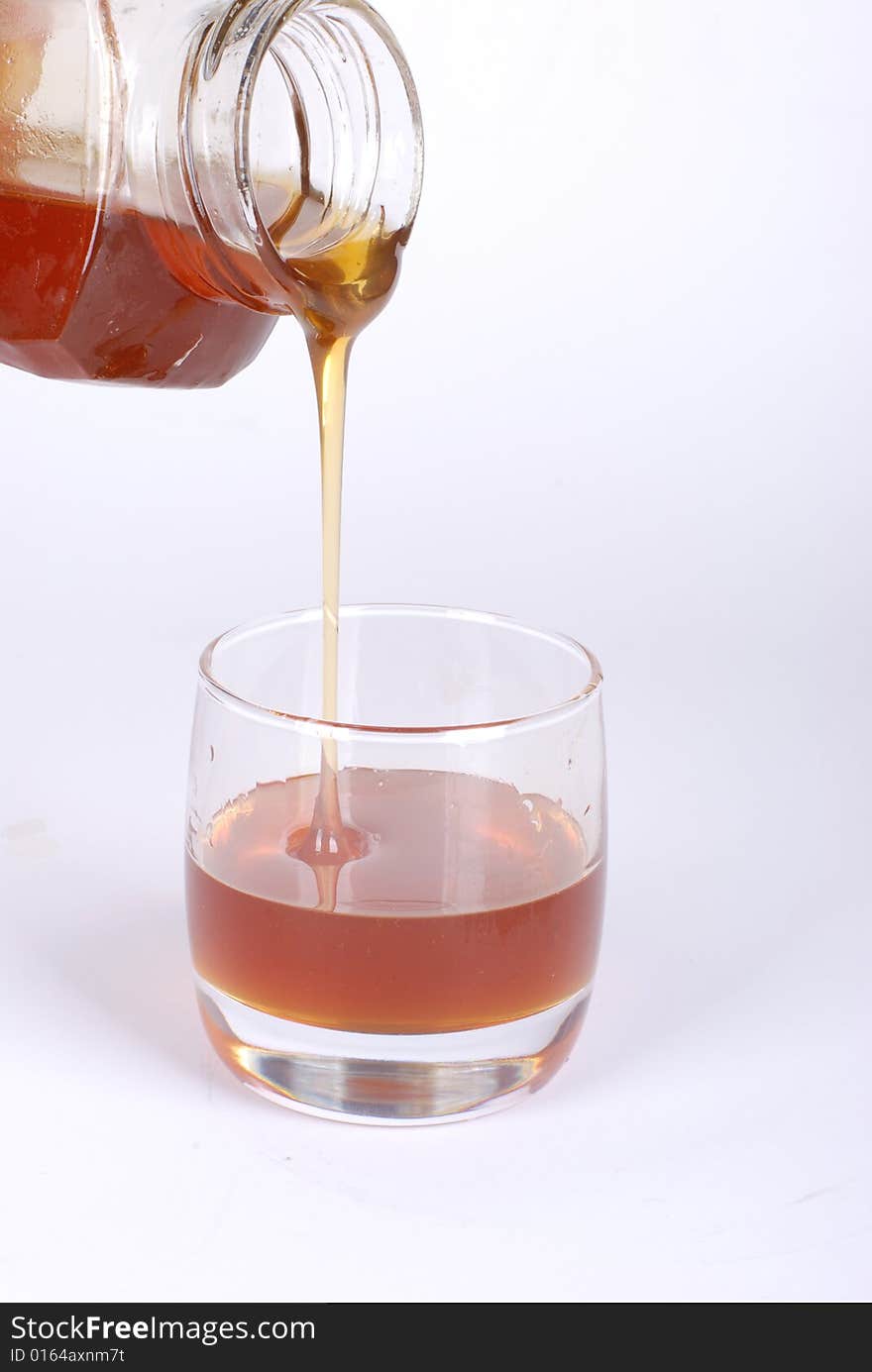 Pouring honey  on white background