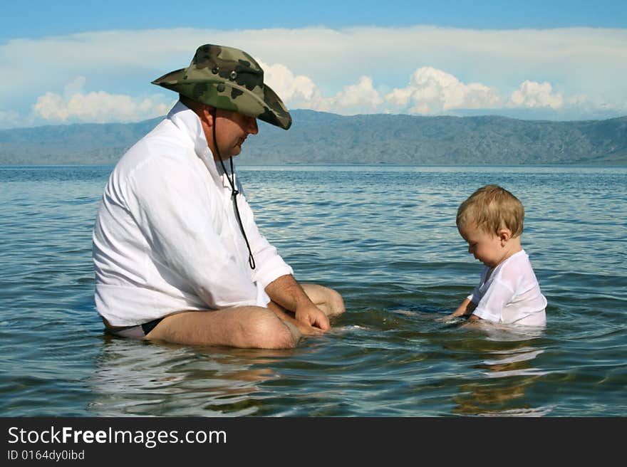 Father and small son play on the water. Father and small son play on the water