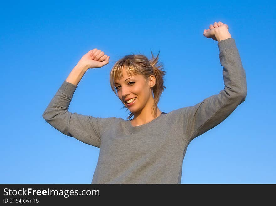 Young woman spreading arms to  blue sky