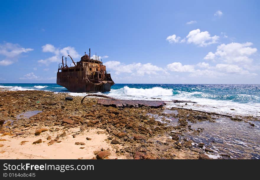 Rusty caribbean shipwreck washing ashore