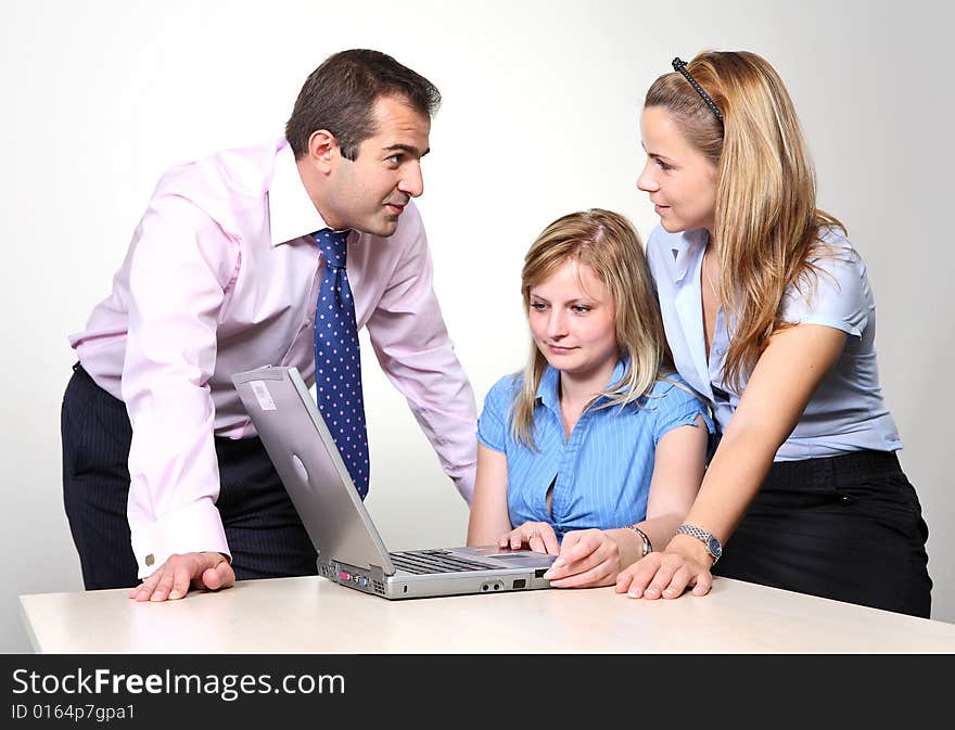 Three colleagues working at a computer: a man received consultation from his female colleagues