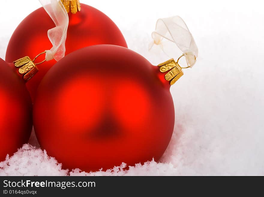 Red Christmas baubles on snow