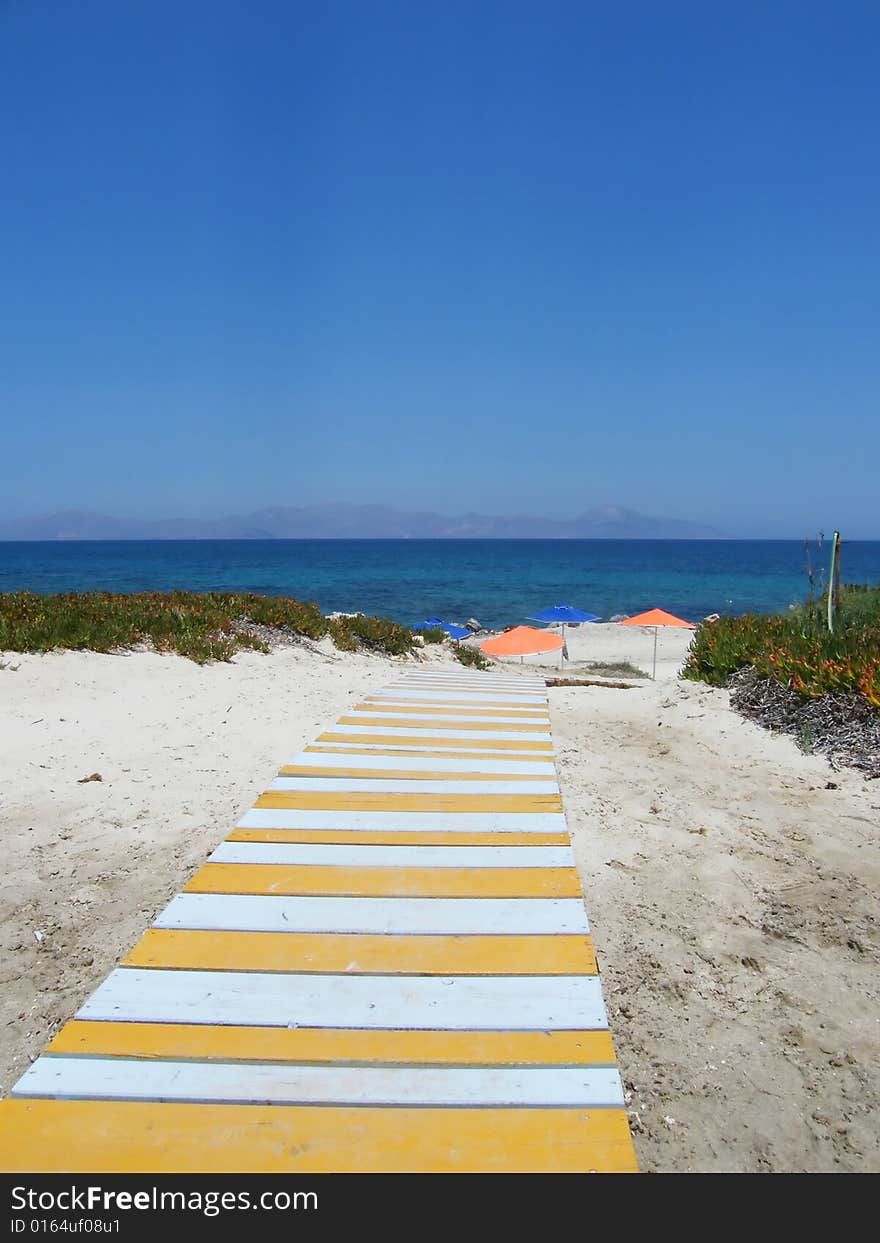 Beach under a blue sky with path