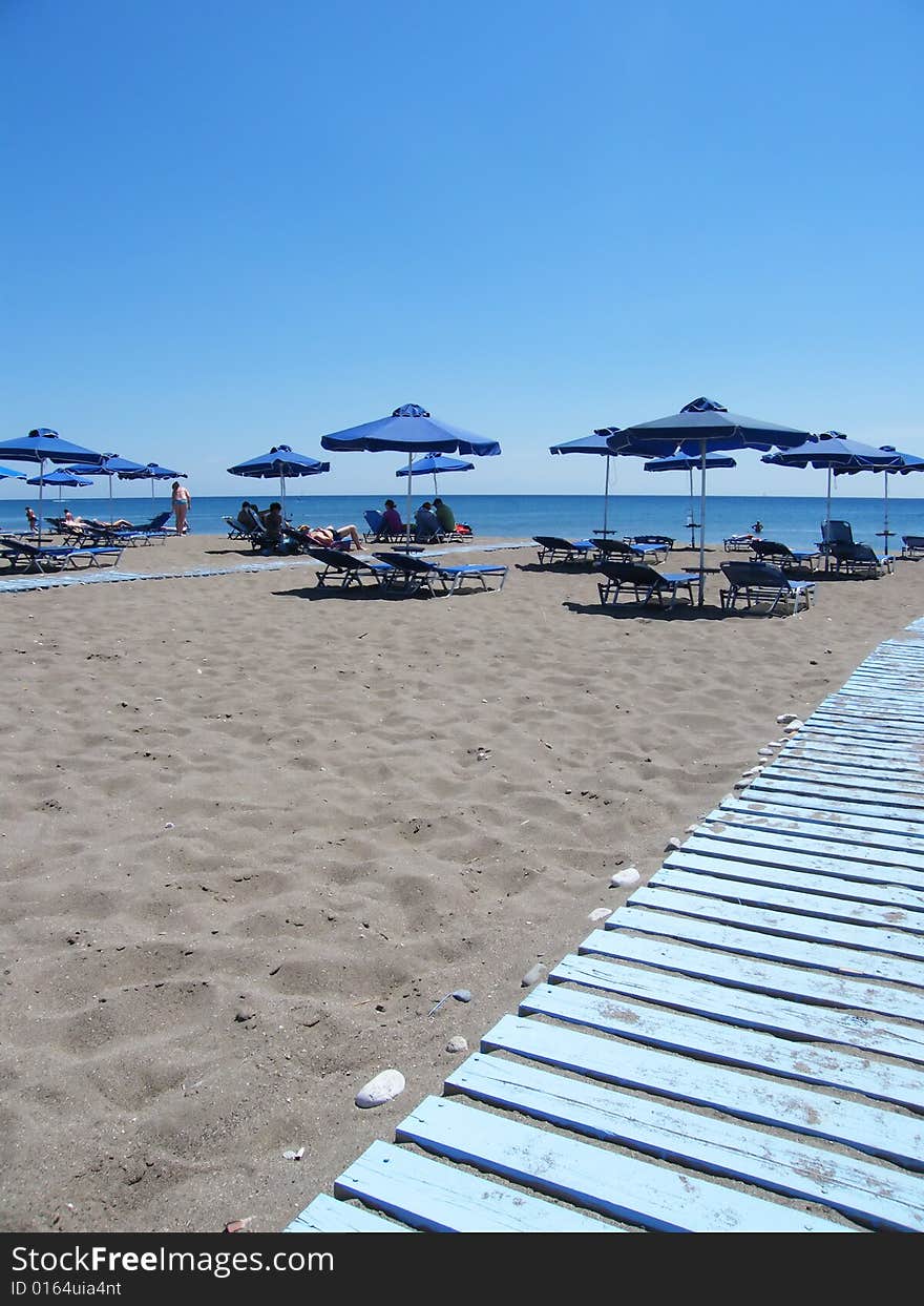 Beach under a blue sky with umbrellas