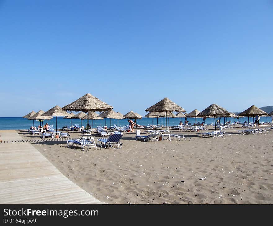 Beach under a blue sky with umbrellas