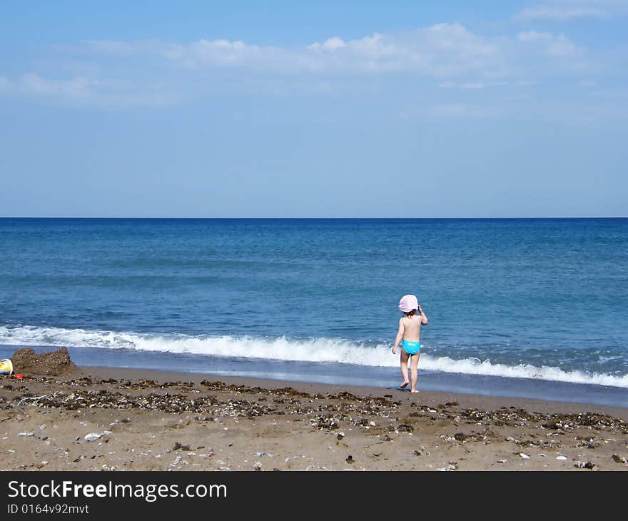 Beach under a blue sky with child