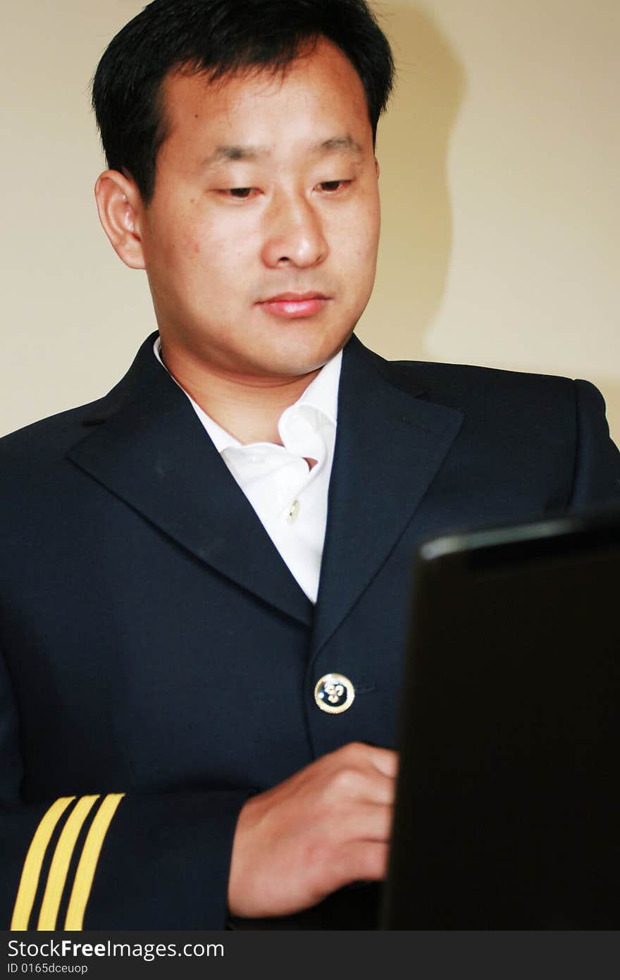 A young pilot using a laptop  at home