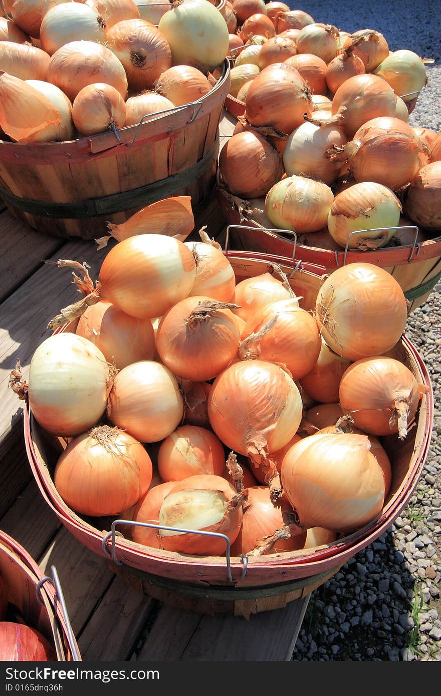 Bushels of fresh picked onions at a roadside market