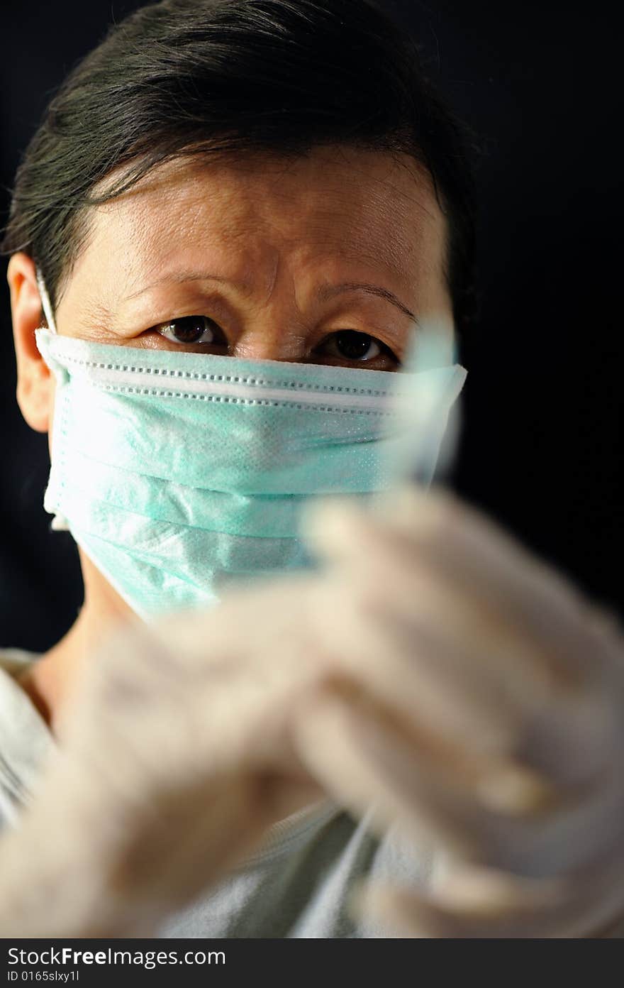 An image of a masked female worker. An image of a masked female worker