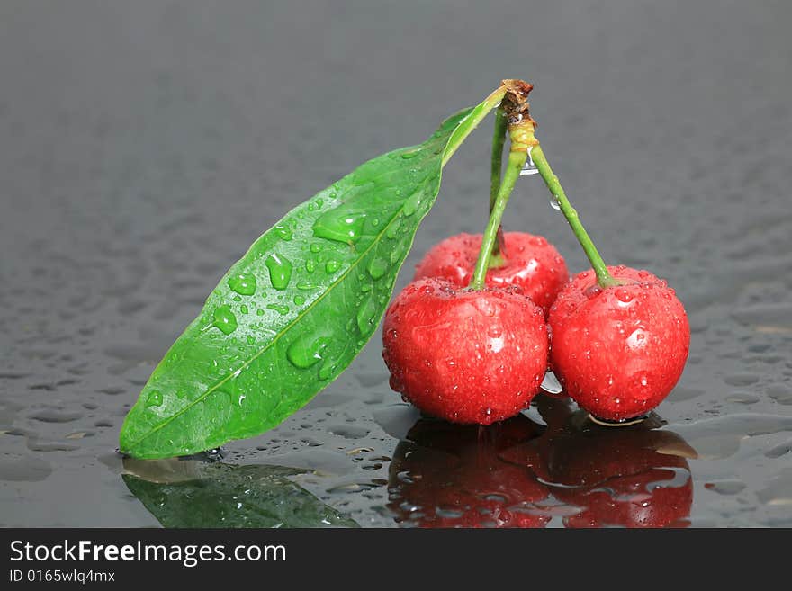 Fresh Cherry with Green Leaf on Wet Glass. Fresh Cherry with Green Leaf on Wet Glass