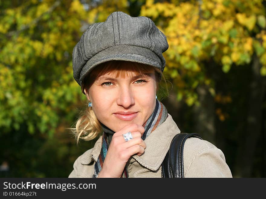 Beautiful blond  young woman in cap in autumn park. Beautiful blond  young woman in cap in autumn park