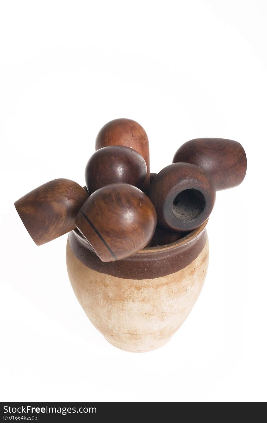 Wooden pipes in clay pot on white background