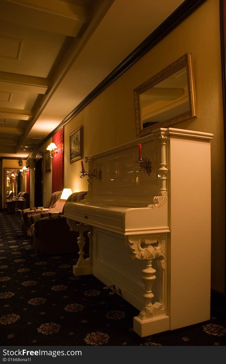 Picture of a lighted lounge area in casino decorated in beautiful vintage style with close-up view of old-fshioned piano. Picture of a lighted lounge area in casino decorated in beautiful vintage style with close-up view of old-fshioned piano