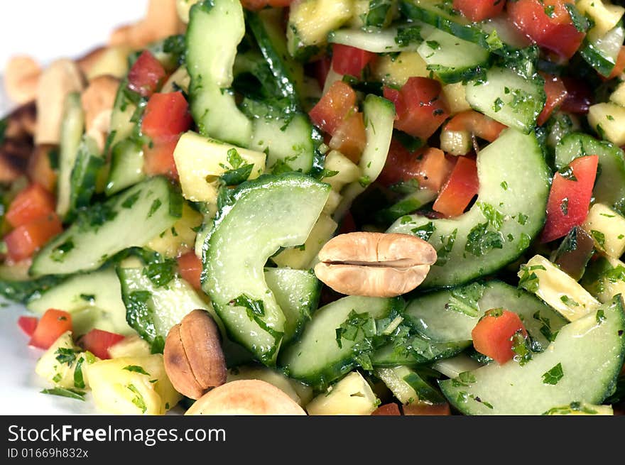 A macro of a plate of delicious cucumber and pineapple salad. Ingredients include pineapple, cucumber, mint, red pepper (capsicum) cashew nuts and sesame oil. A macro of a plate of delicious cucumber and pineapple salad. Ingredients include pineapple, cucumber, mint, red pepper (capsicum) cashew nuts and sesame oil.