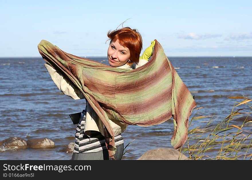 Red haired woman with scarf. Windy day.