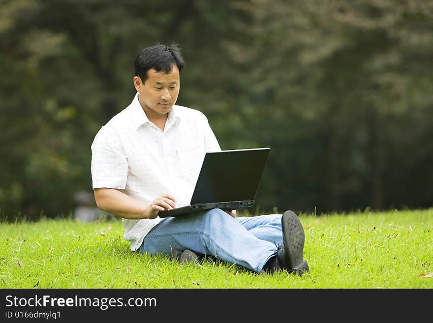 A young man using a laptop outdoors