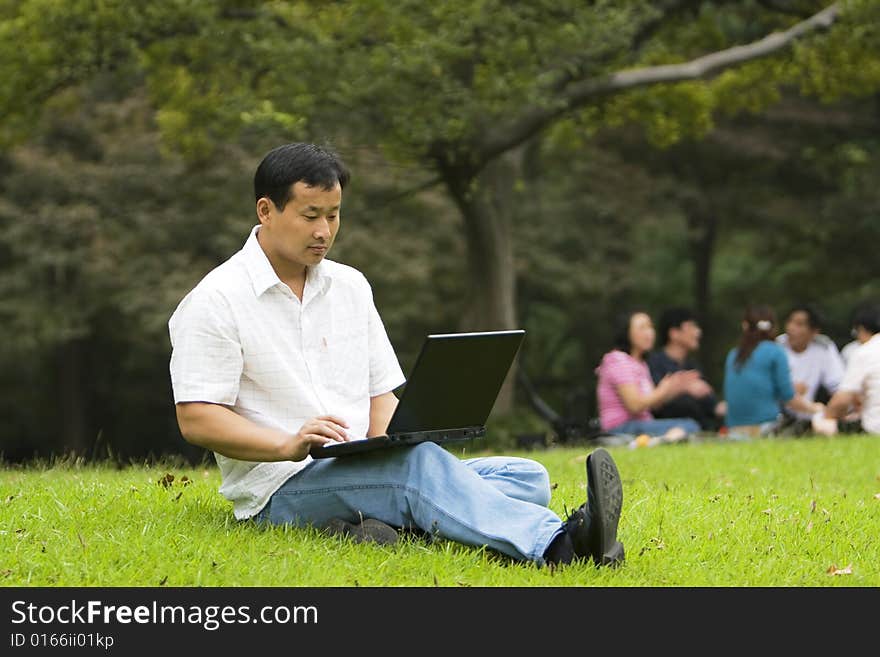 A young man using a laptop outdoors