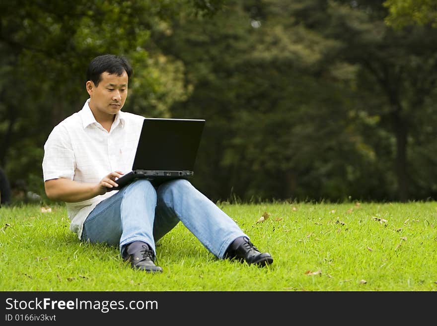 A young man using a laptop outdoors