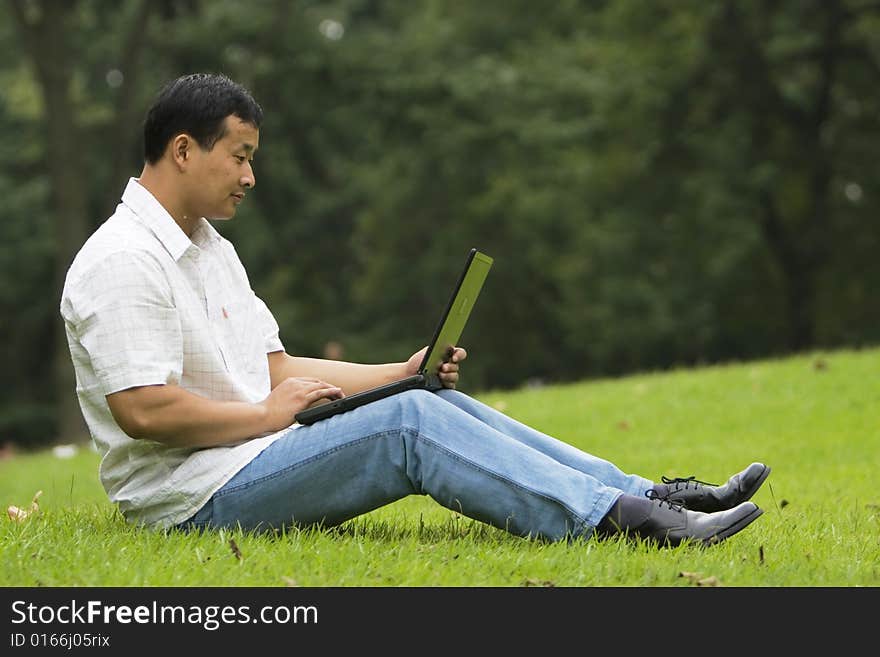 A young man using a laptop outdoors