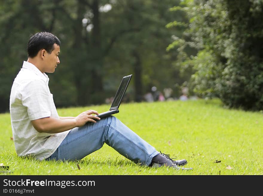 A young man using a laptop outdoors