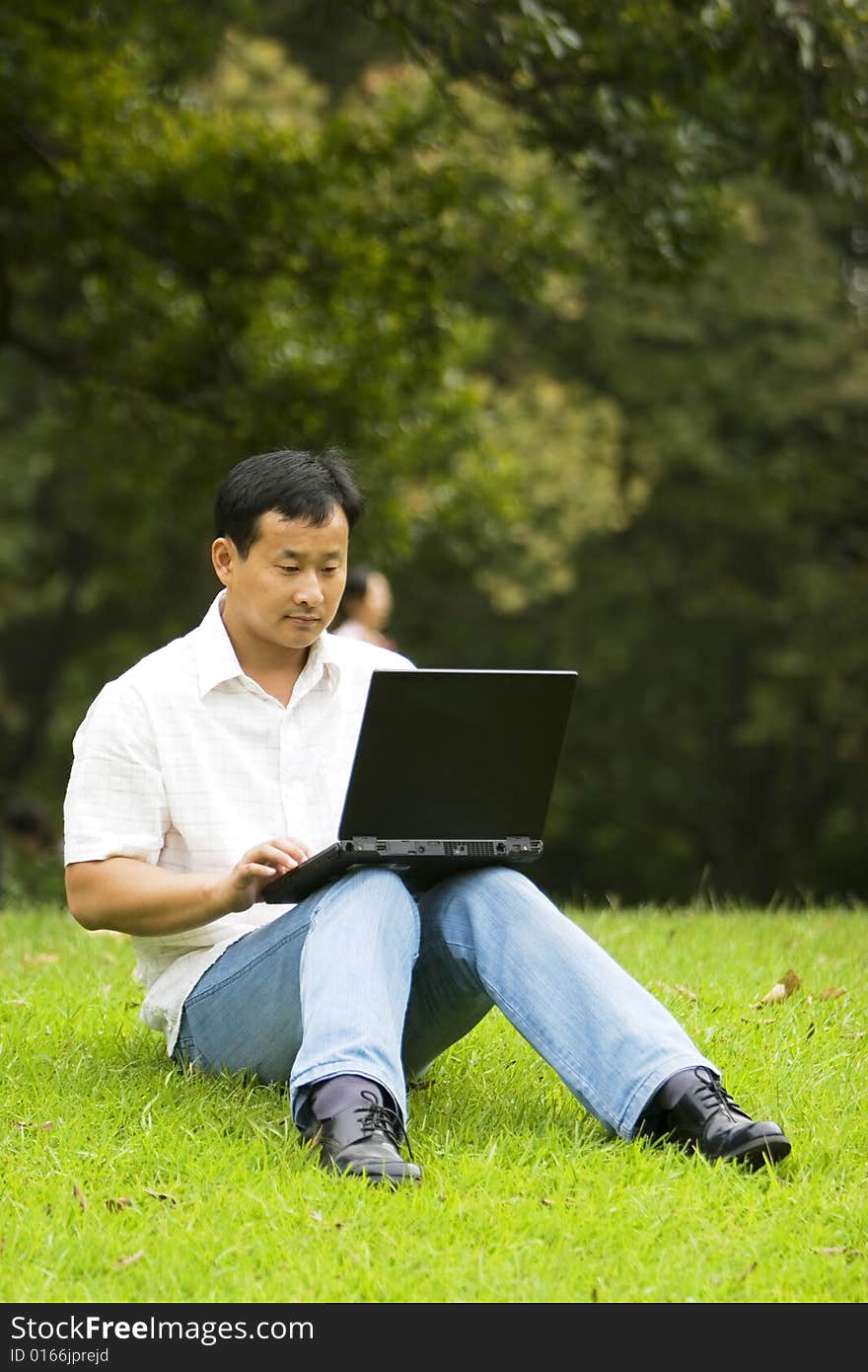 A young man using a laptop outdoors