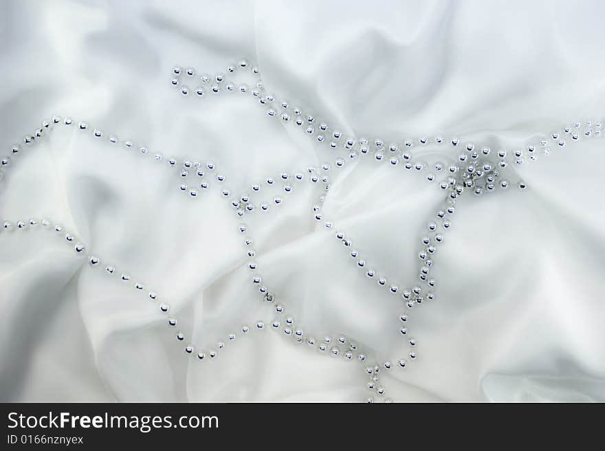 Silver beads on white silk