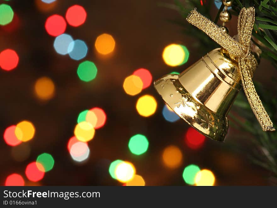 Christmas bell hanging on a branch tree, lights background