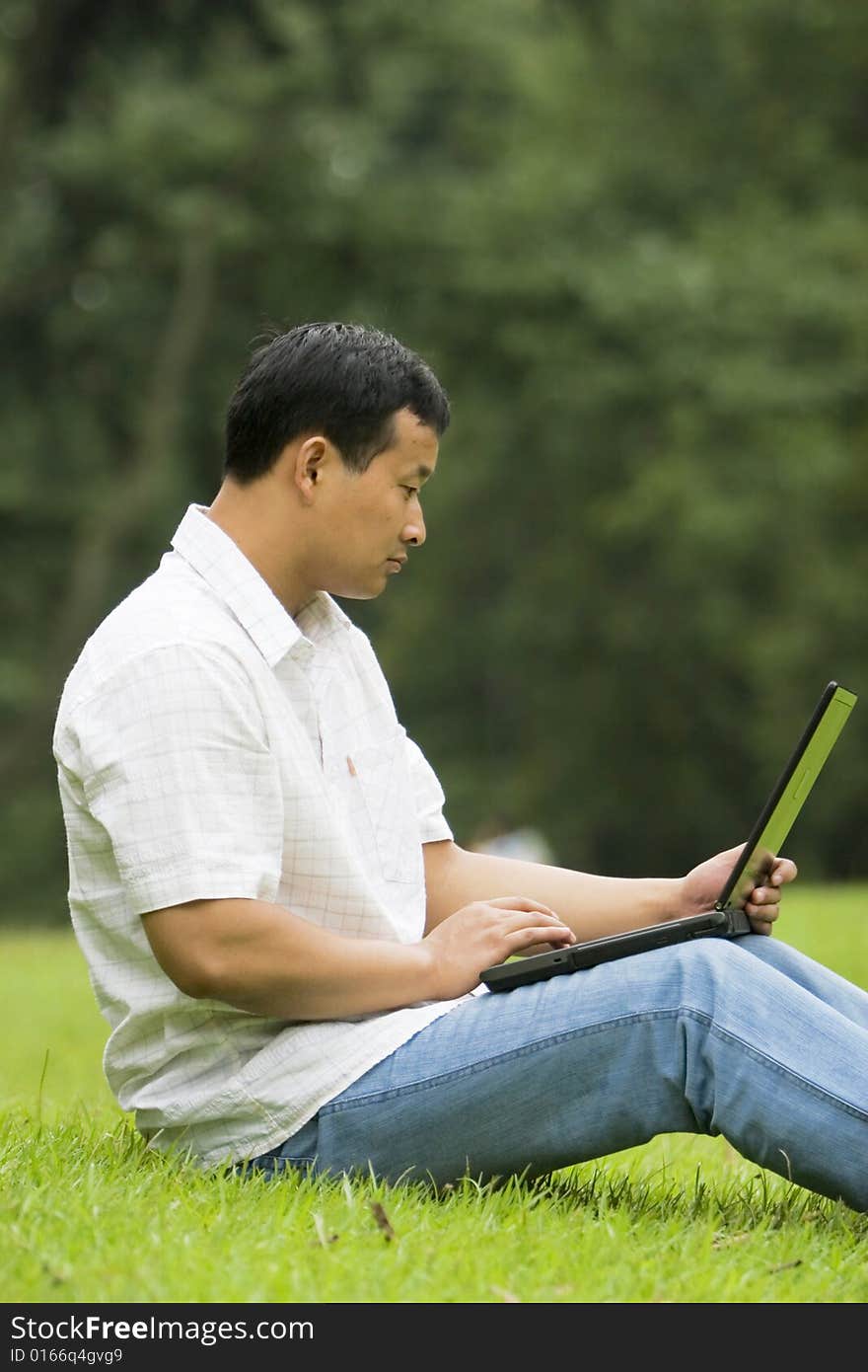 A young man using a laptop outdoors