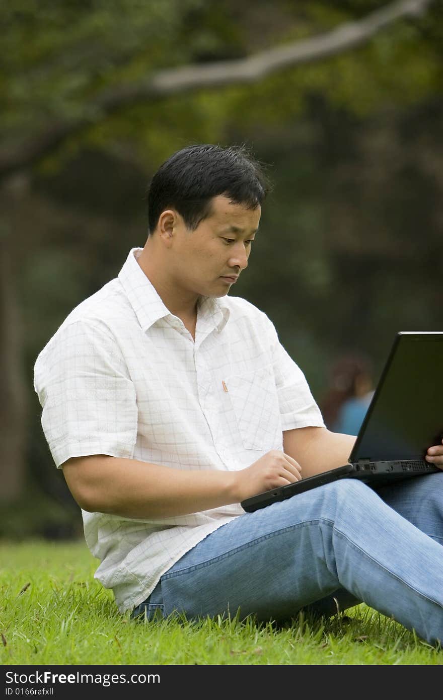 A young man using a laptop outdoors