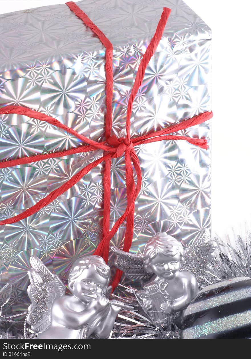 In silver wrapped christmas present with christmas ornaments. In silver wrapped christmas present with christmas ornaments.