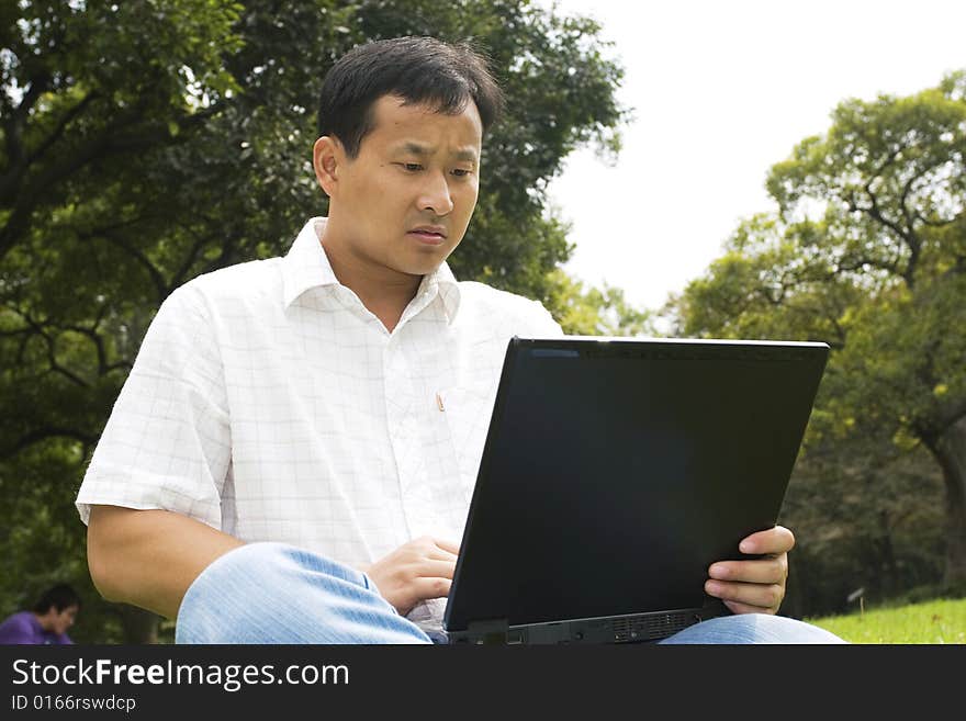 A young man using a laptop outdoors