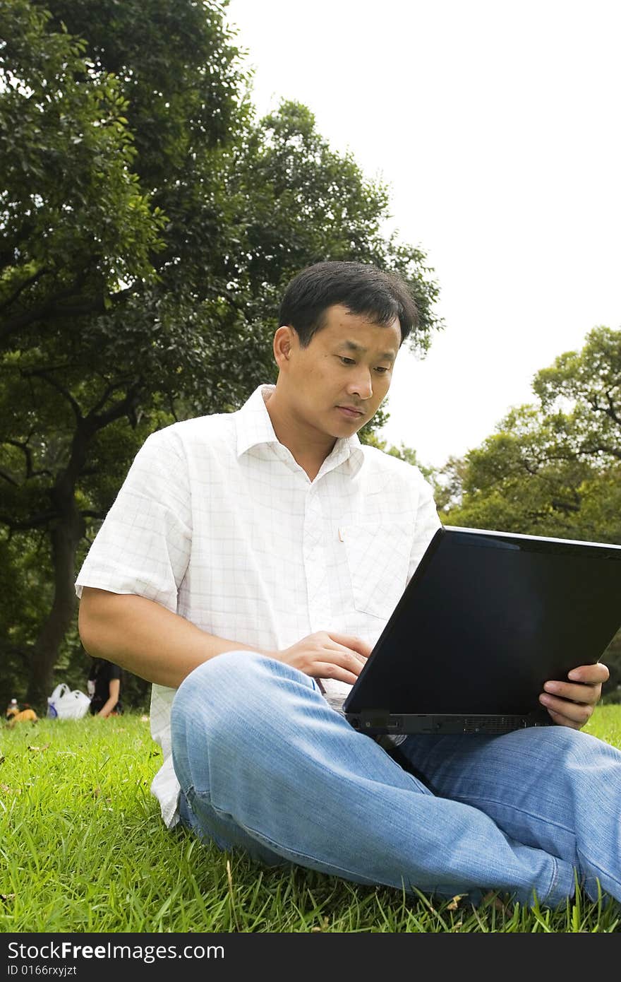 A young man using a laptop outdoors