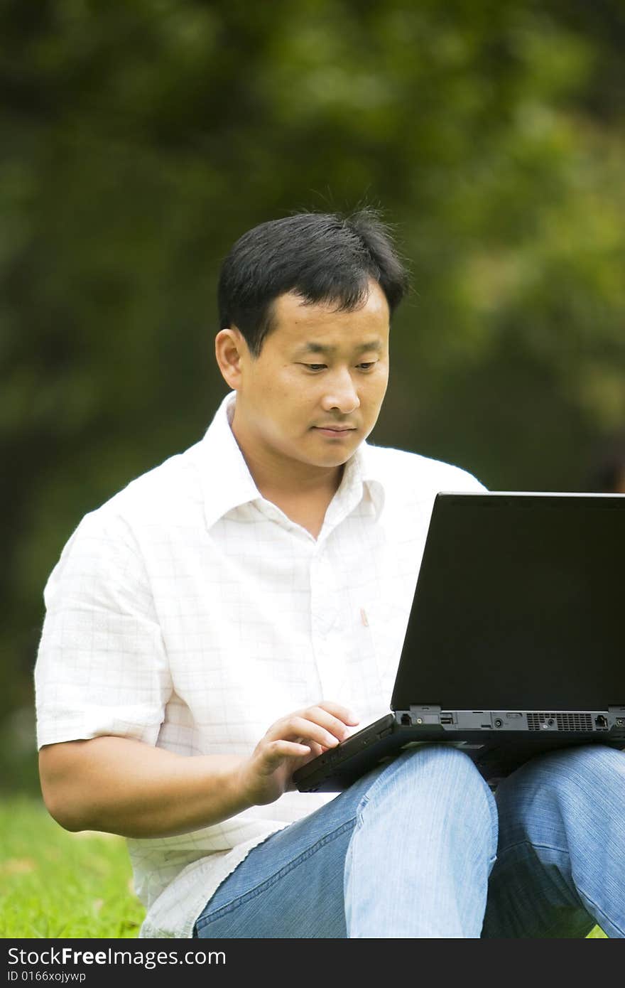 A young man using a laptop outdoors